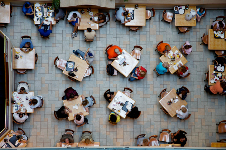 Overhead view of people eating in a cafeteria.