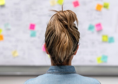 Woman standing in front of a whiteboard, outlining her business plan
