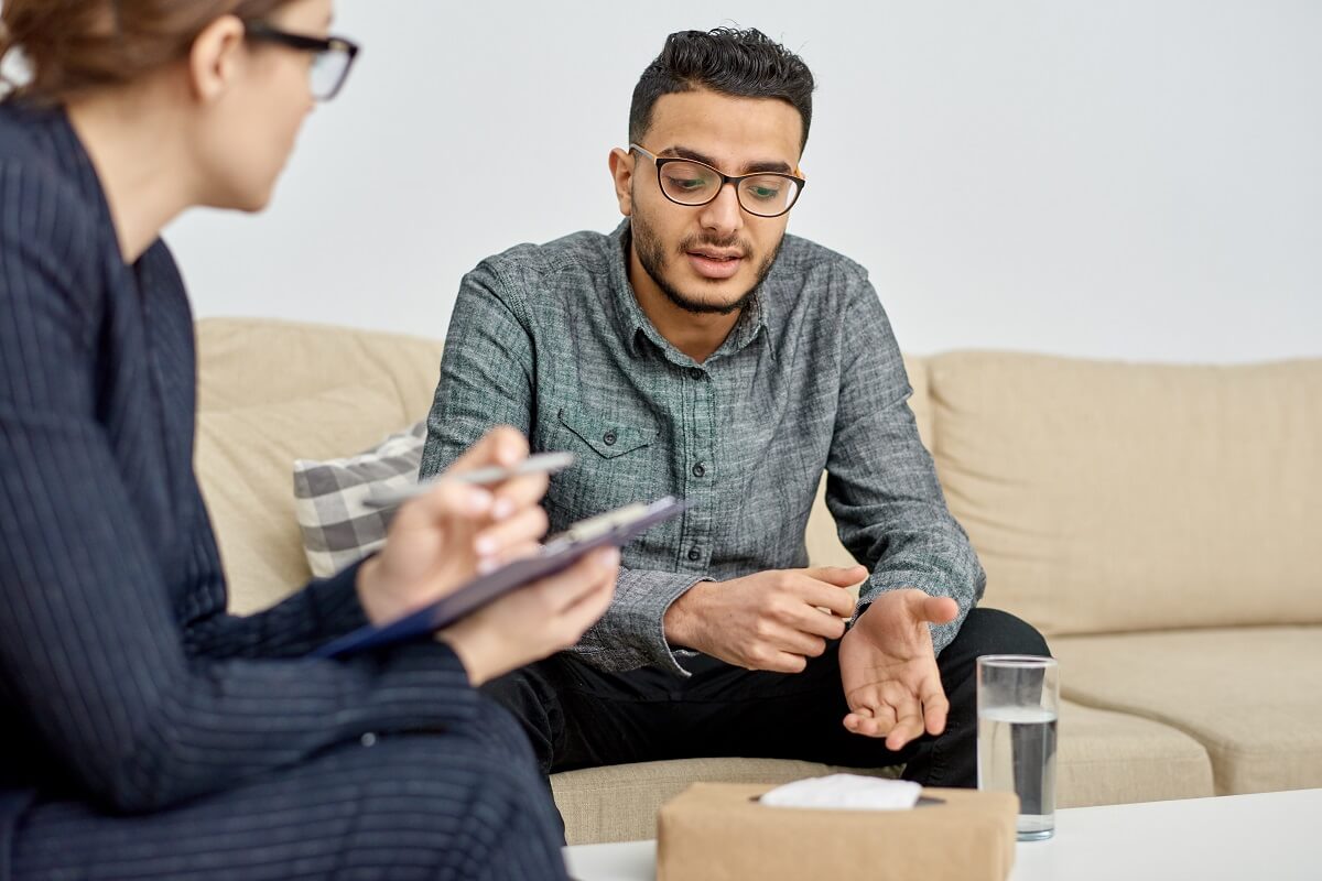 Man sitting on couch and talking to his therapist