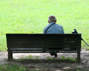 Older man sitting alone on park bench
