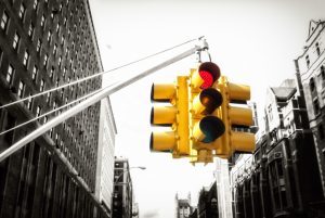 Angled-up view of bright traffic light on grayscale street