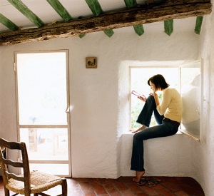 Woman sitting in window of cottage